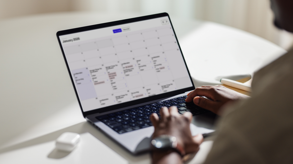 A man on a laptop using a calendar UI