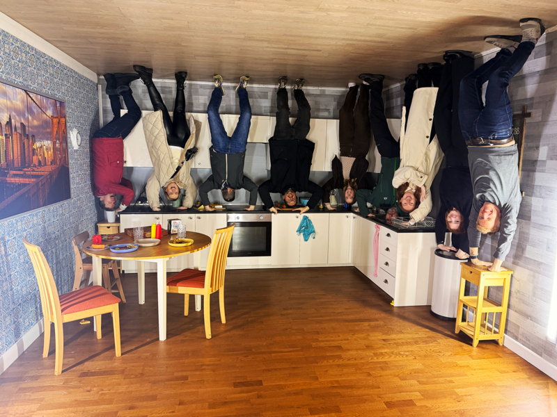 The Grandad Team appearing to be standing on the ceiling of a kitchen in the upside down house
