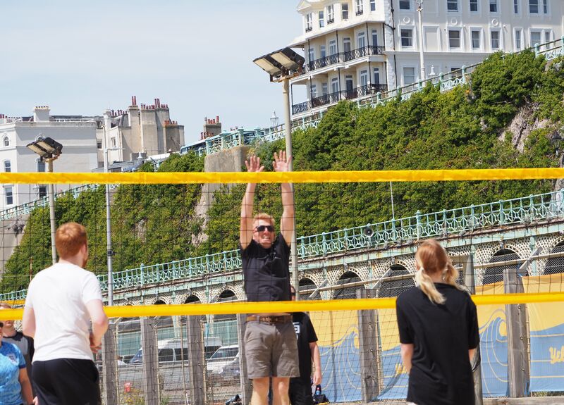 The Grandad Team playing beach volleyball in the sun in Brighton