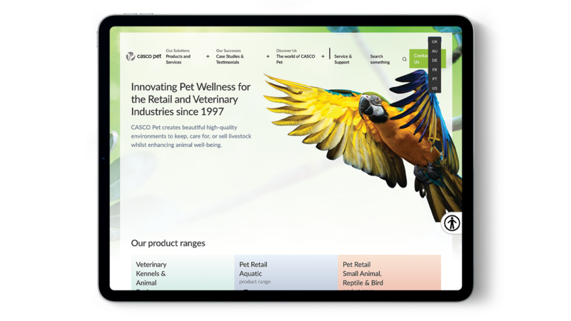 A tablet shows the Casco Pet website with language options open.