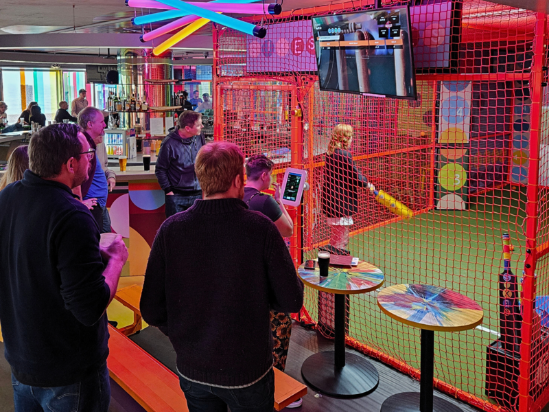 Our team at a colourful indoor cricket venue, watching as Ajna, our marketing intern, get's ready to bat.
