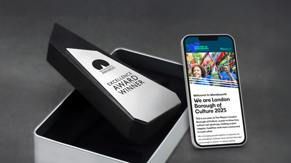 A WE Award coming out of it's box, besides a phone showing the Welcome to Wandsworth website