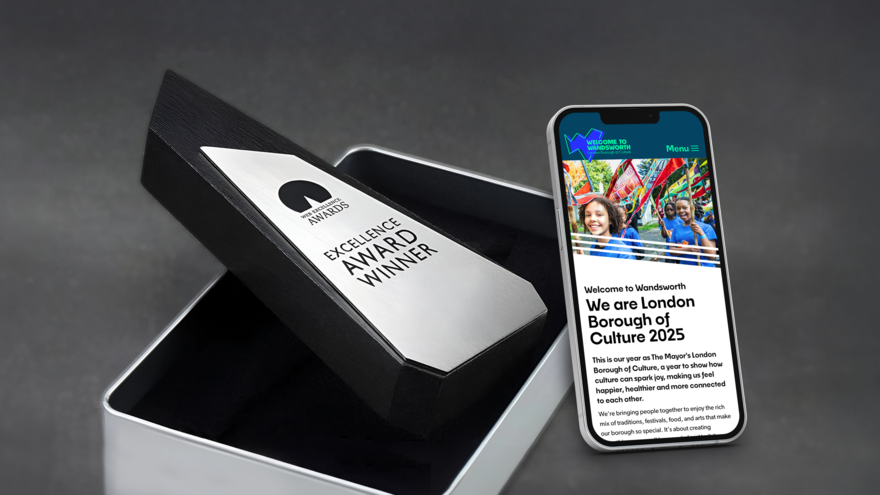 A WE Award coming out of it's box, besides a phone showing the Welcome to Wandsworth website