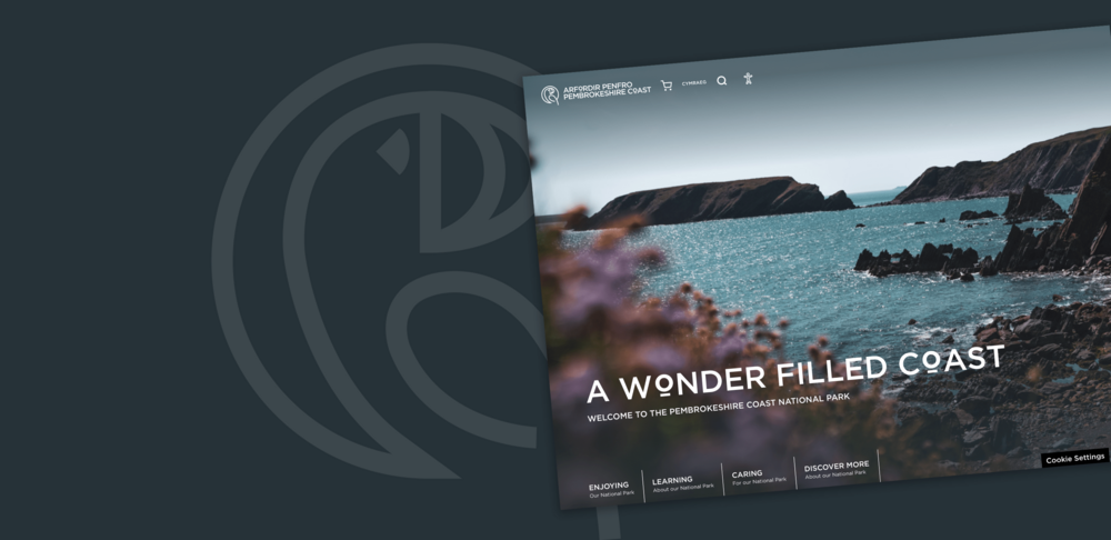 A screenshot of the Pembrokeshire Coast website over a grey background with a lighter grey Pembrokeshire Coast icon of a bird in a circle. In the bottom left is the Pembrokeshire Coast logo