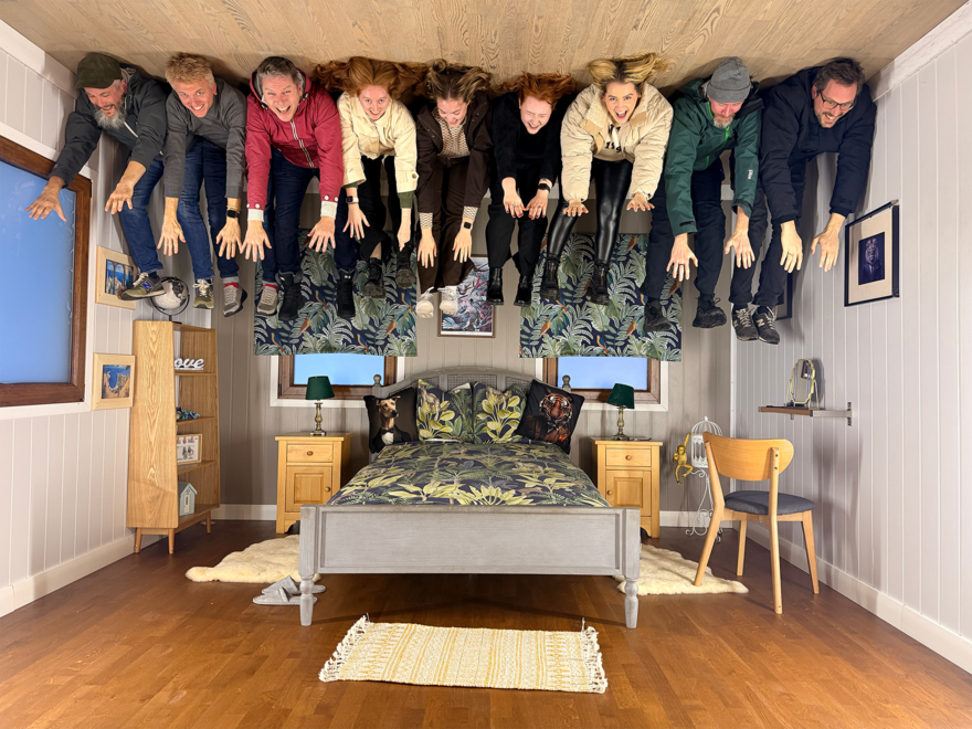 The Grandad Team appearing to be lying on the ceiling of a bedroom in the upside down house