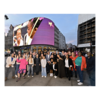A large group pose in front of the Piccadilly Sceen