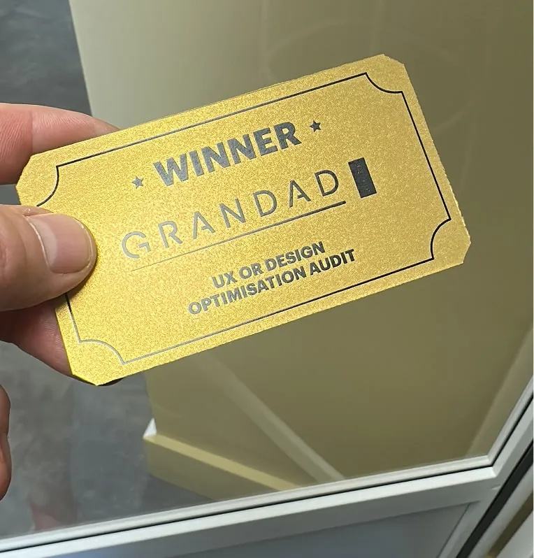 A golden card with text reading Winner. Grandad. UX or Design Audit.